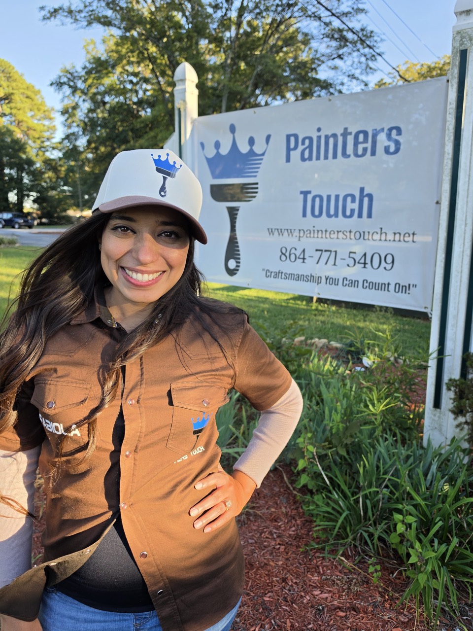Fabiola, Office Manager, General Manager and Owner, in front of the Painters Touch sign
